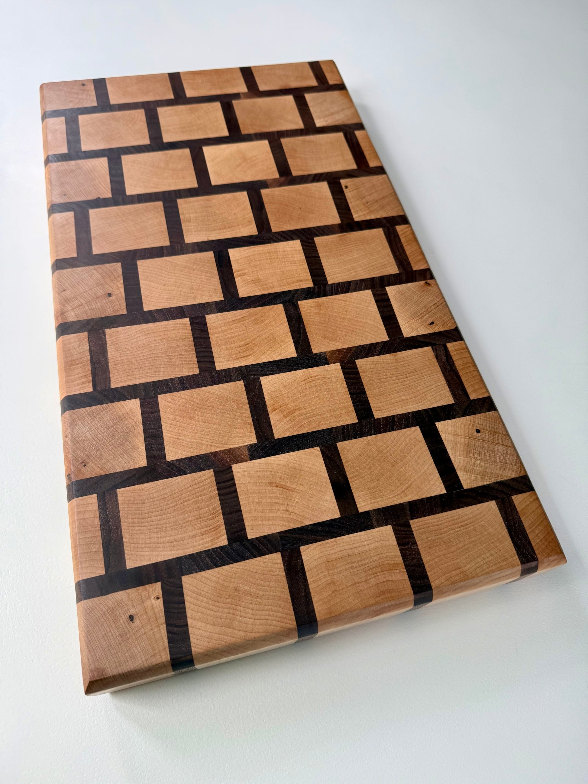 Wooden cutting board with a checkered pattern on a white background