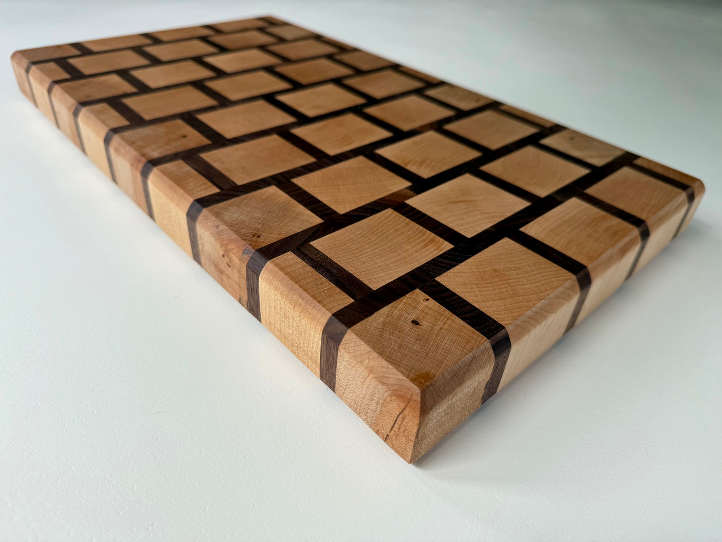 Wooden cutting board with a checkered pattern on a white background