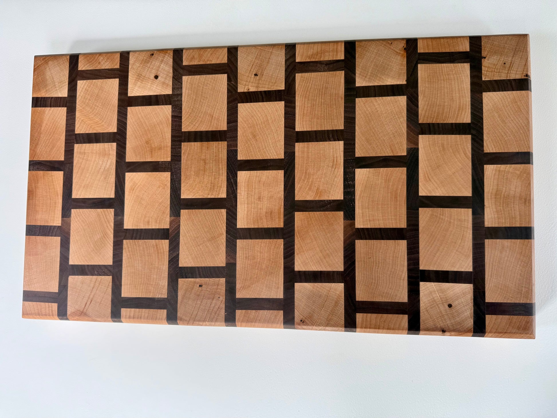 Wooden cutting board with a checkered pattern on a white background