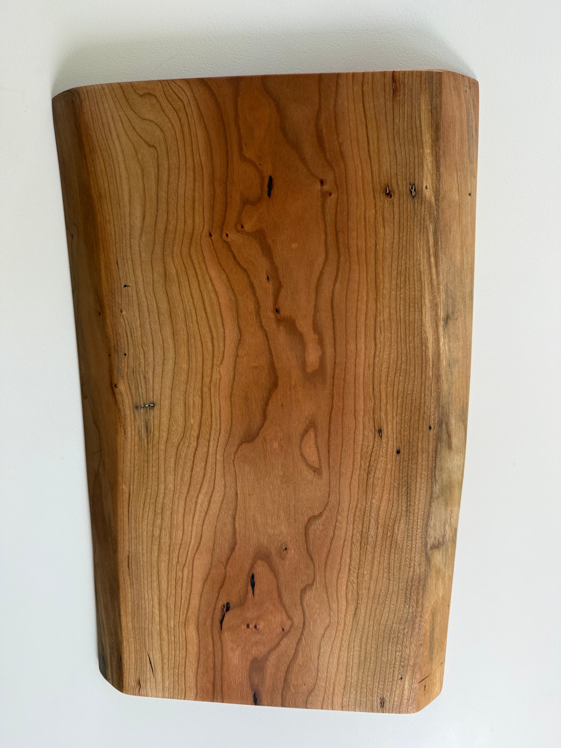 Wooden charcuterie board with live edge on a white background