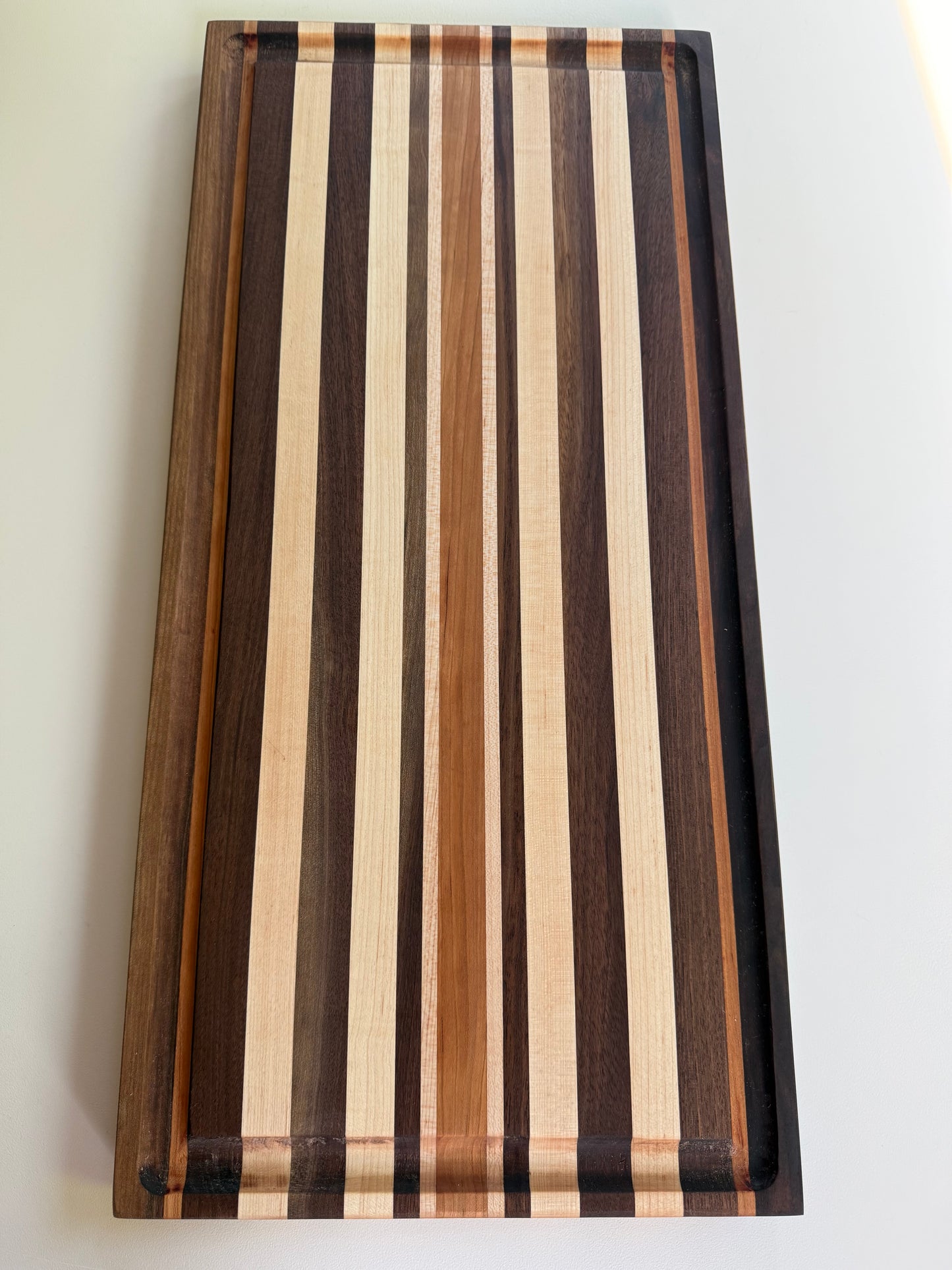 Wooden cutting board with striped pattern on a white background