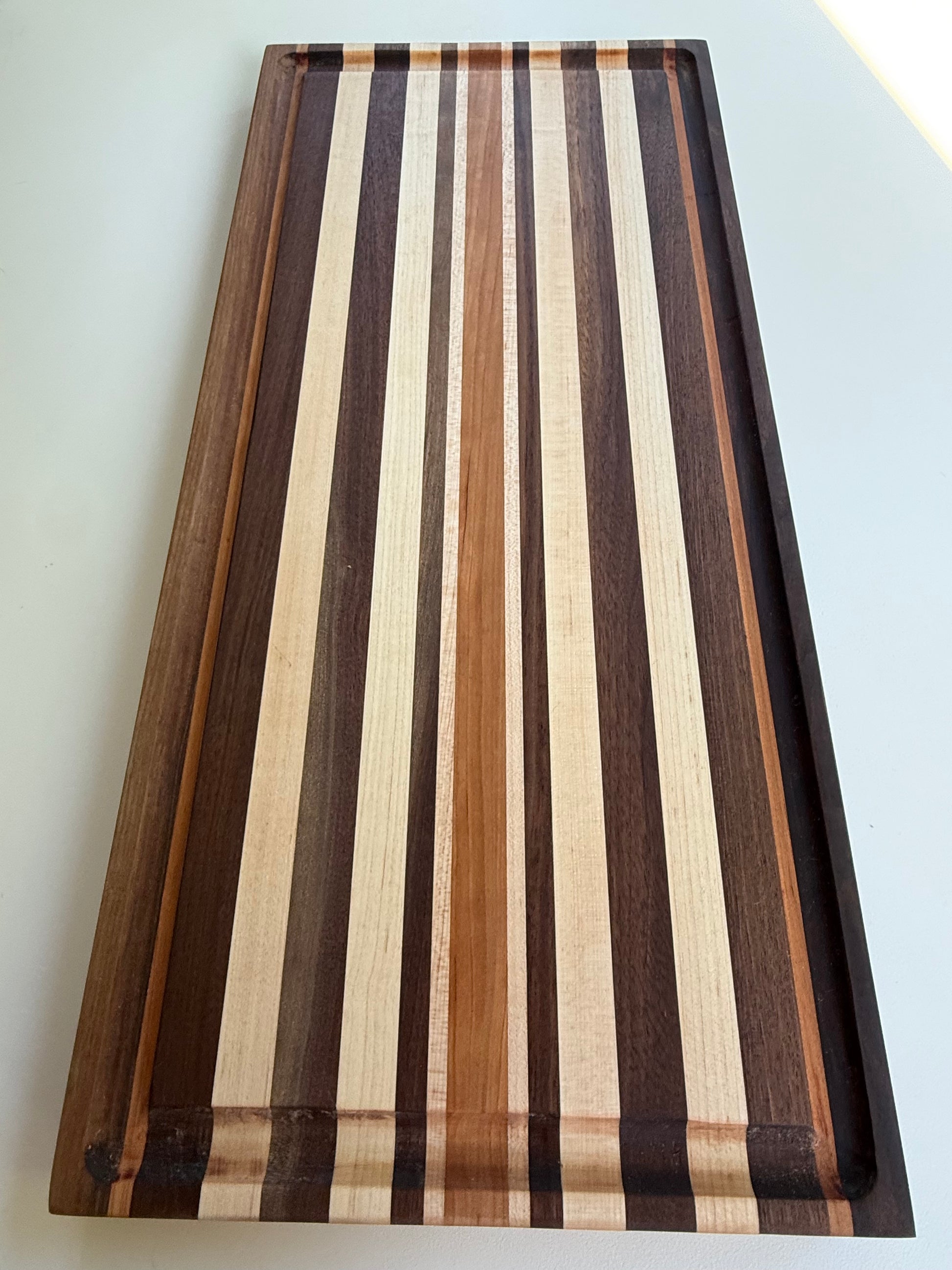 Wooden cutting board with striped pattern on a white background