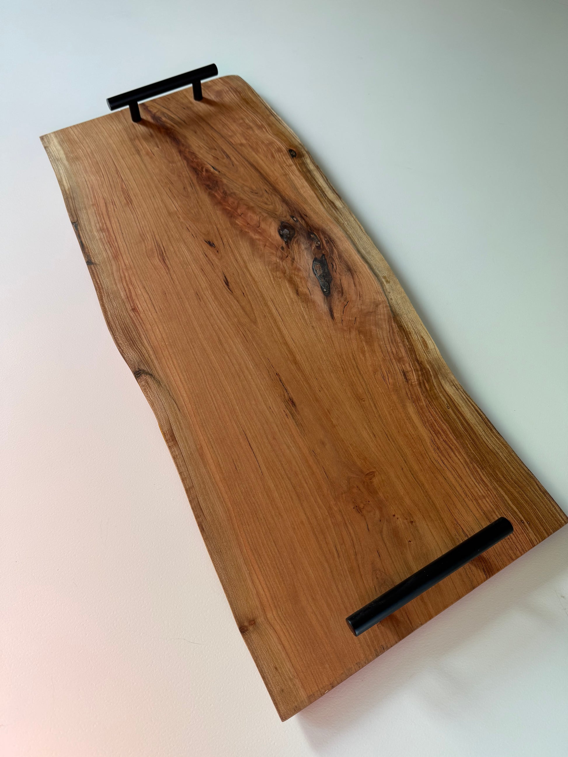 Wooden charcuterie board with black handles
