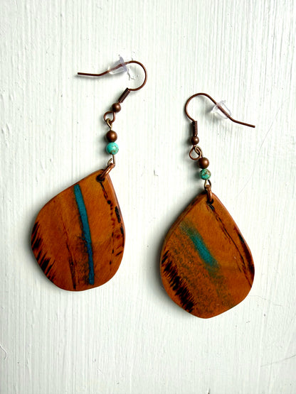 Wooden earrings with blue accents on a white background