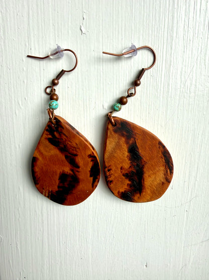 Wooden earrings with blue accents on a white background