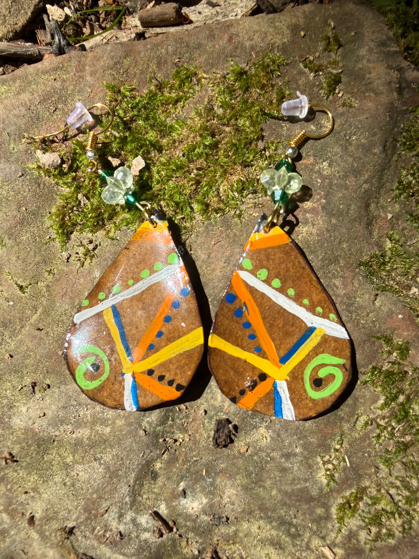 Decorative earrings with colorful patterns on a stone surface