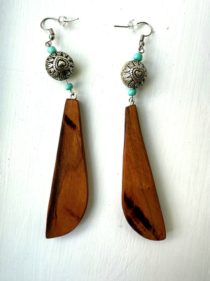 Wooden earrings with turquoise accents and silver beads on a white background