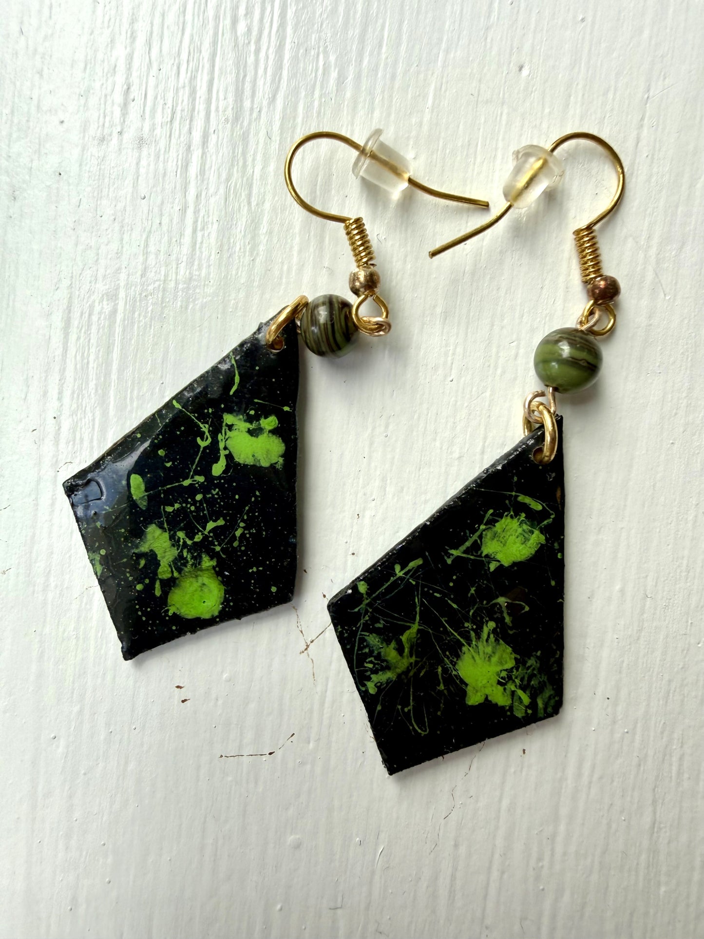 Pair of earrings with black and green marbled design on each one