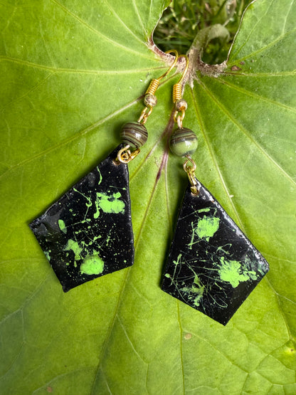 Pair of earrings with black and green marbled design on each one 