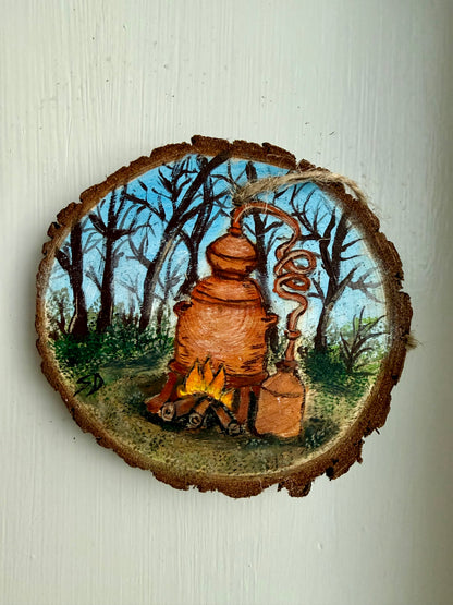 Wooden ornament featuring a moonshine still in a forest