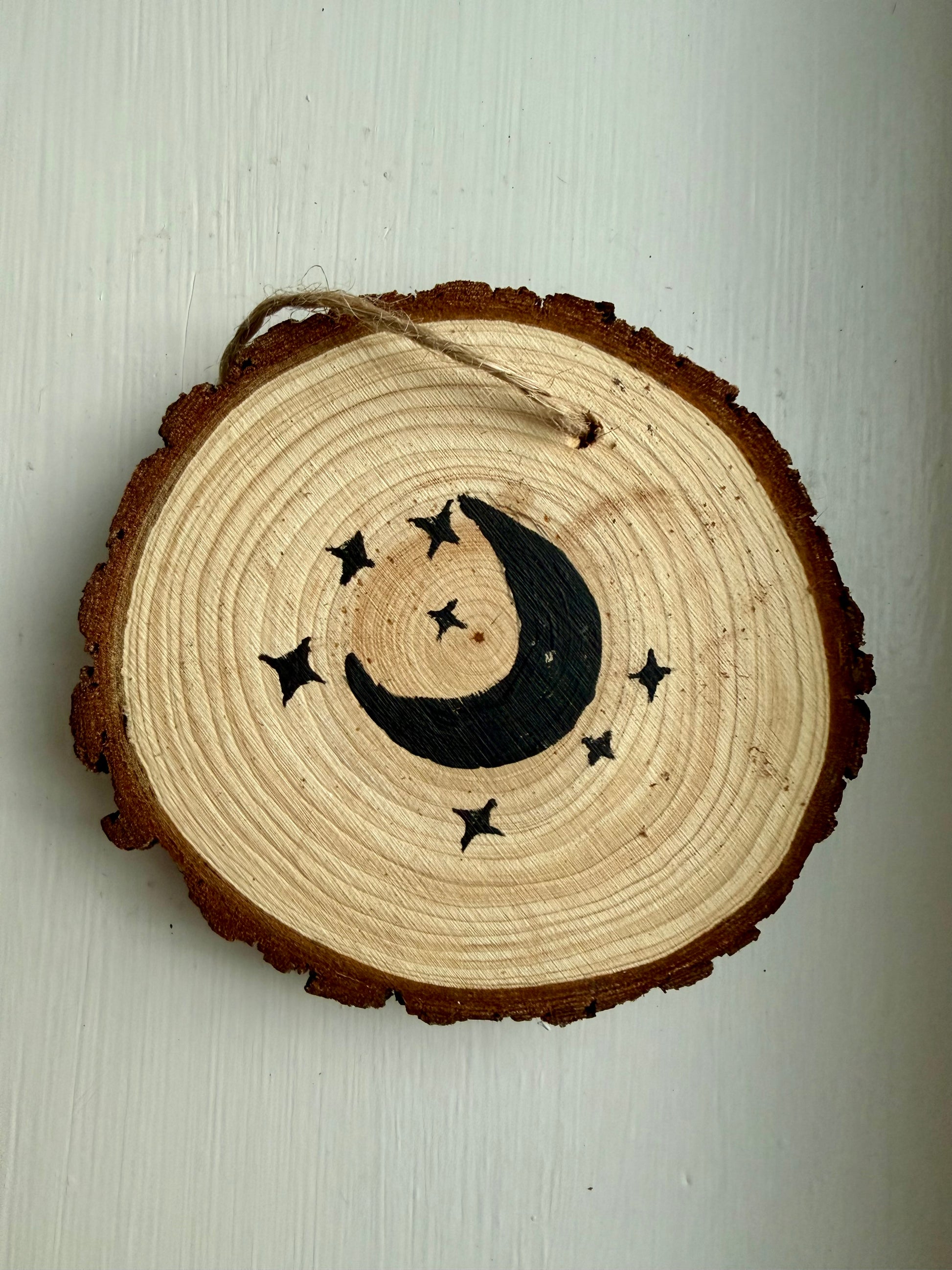 Wooden ornament featuring a black moon and star design