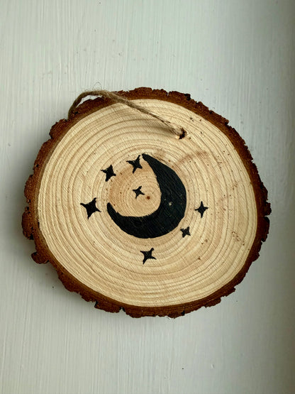 Wooden ornament featuring a black moon and star design