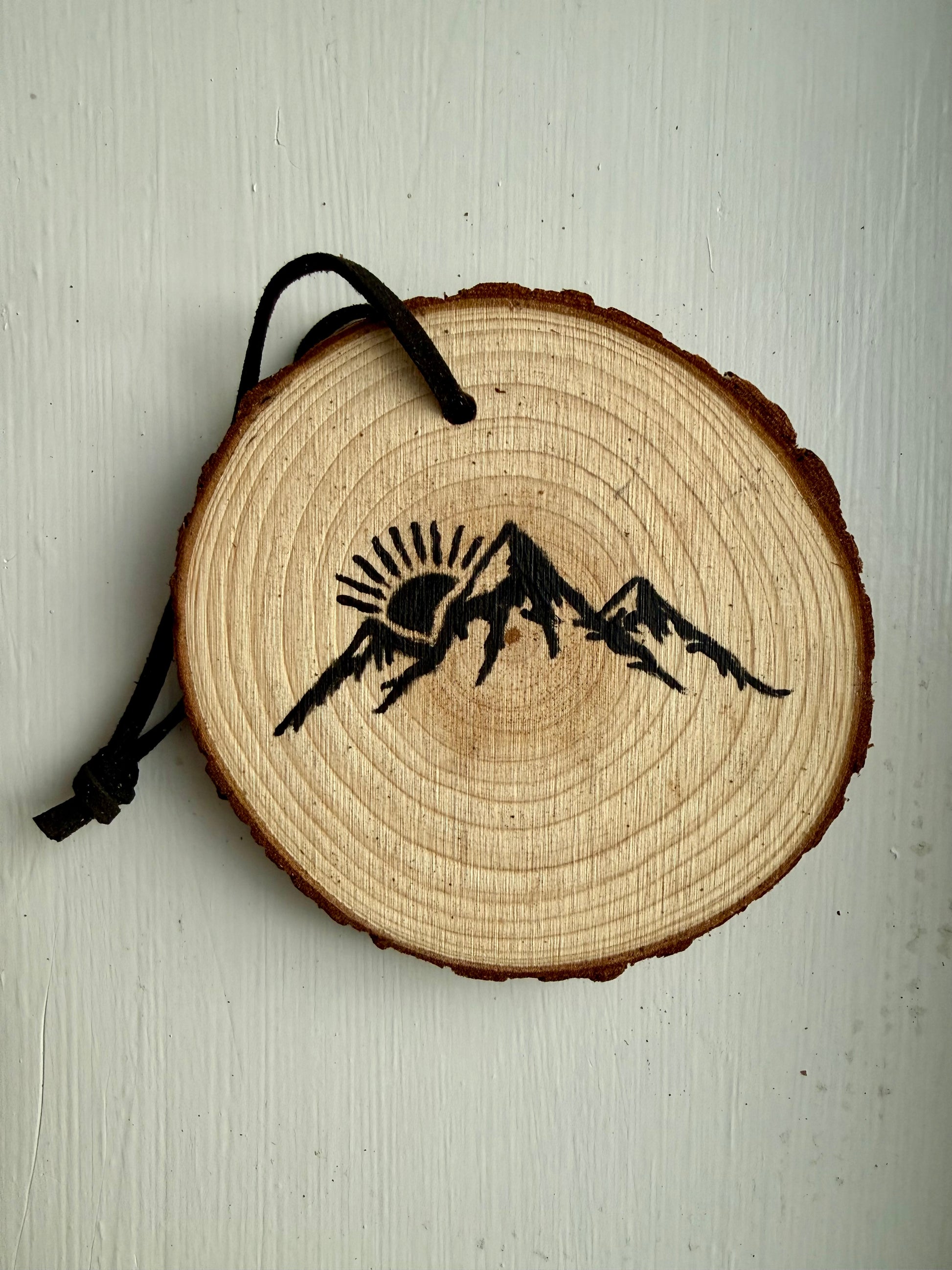 Wooden ornament featuring a black mountain design 