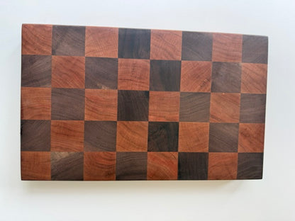 Square cutting board with a checkered cherry and walnut wood design