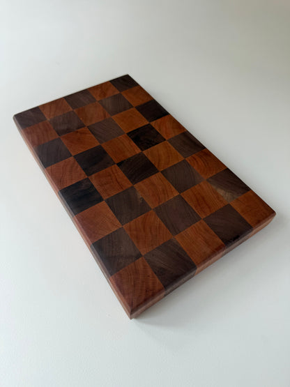 Square cutting board with a checkered cherry and walnut wood design