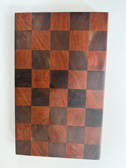 Square cutting board with a checkered cherry and walnut wood design