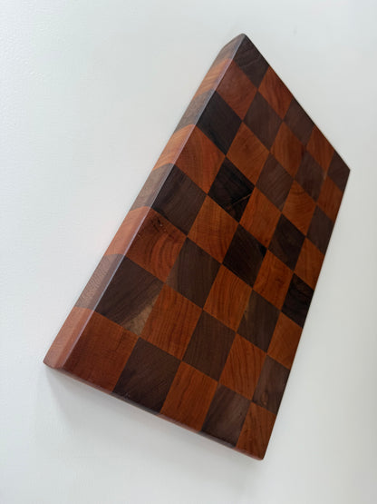Square cutting board with a checkered cherry and walnut wood design