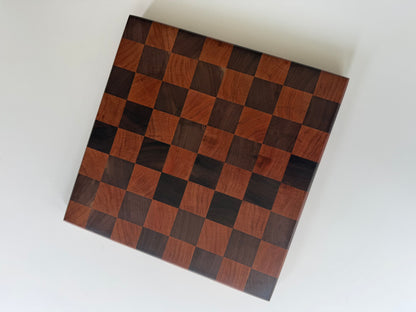 Square cutting board with a checkered cherry and walnut wood design
